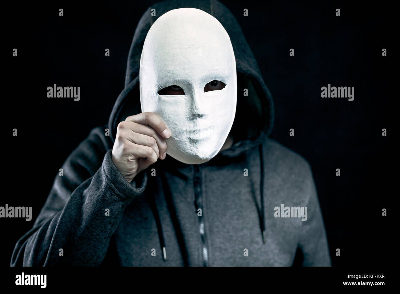 Man holding masque blanc pour cacher son visage Banque D'Images