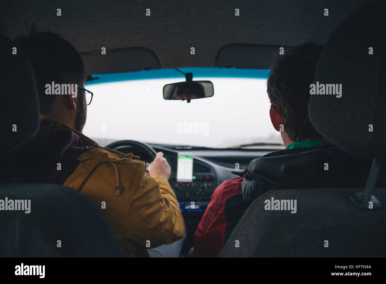 Deux homme conduisant par autoroute avec la navigation sur le téléphone Banque D'Images