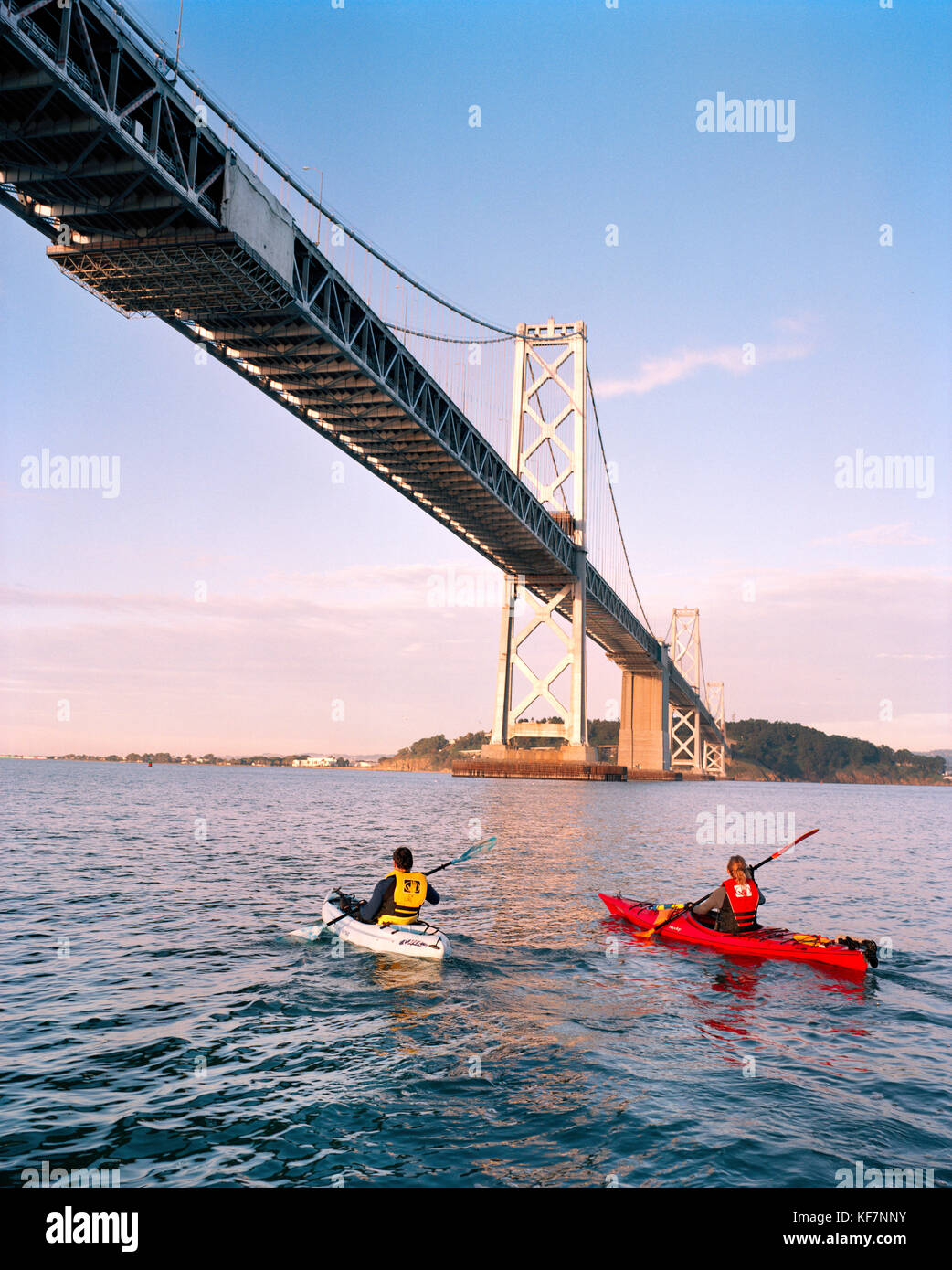 États-unis, Californie, San Francisco, un homme et une femme kayak dans la baie de san francisco sous le Bay Bridge, l'île de Yerba Buena dans la distance Banque D'Images