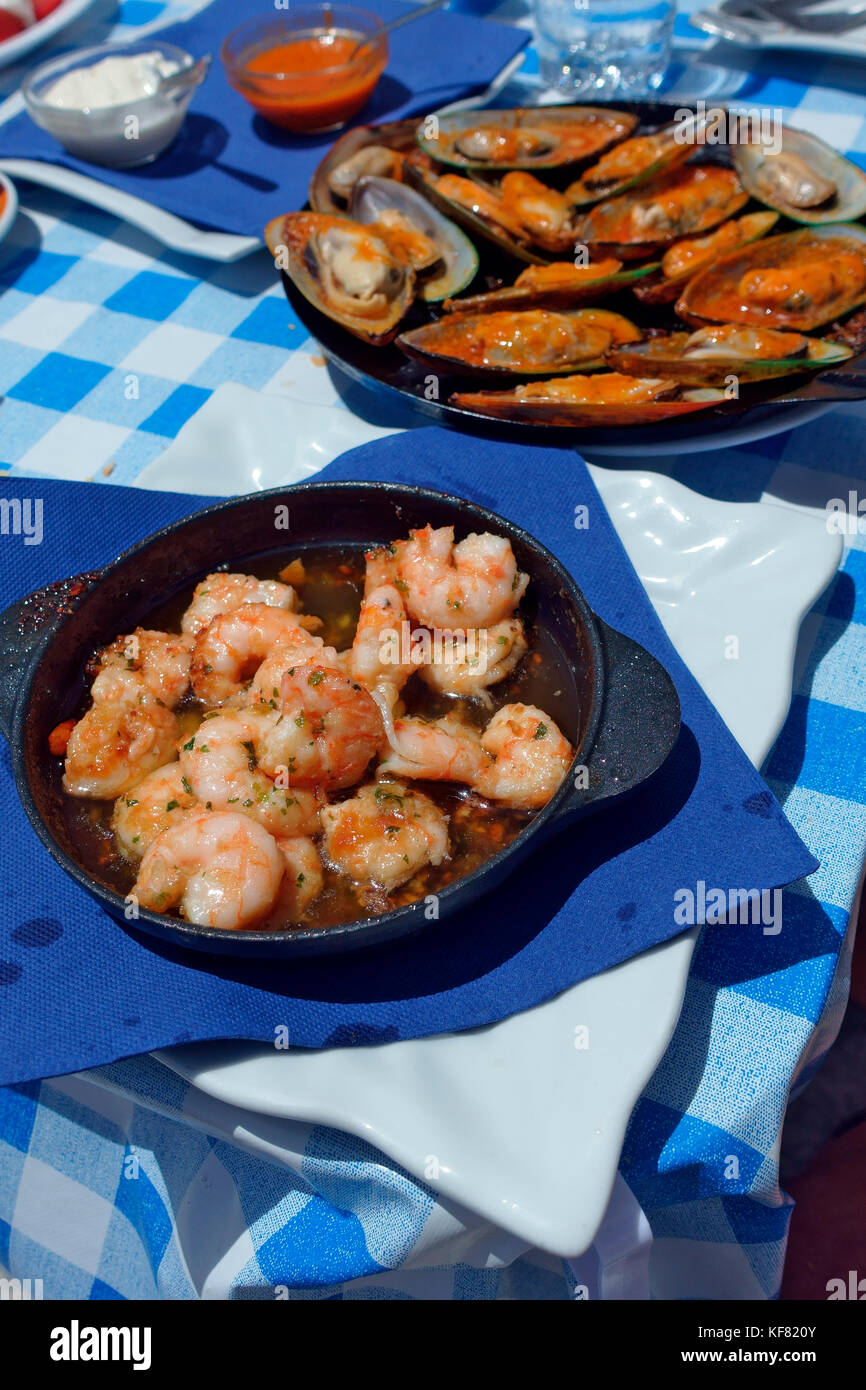 Les crevettes cuites et les moules dans un bain poêlons sur une nappe à carreaux bleu dans le village d'El Cotillo, Fuerteventura Banque D'Images