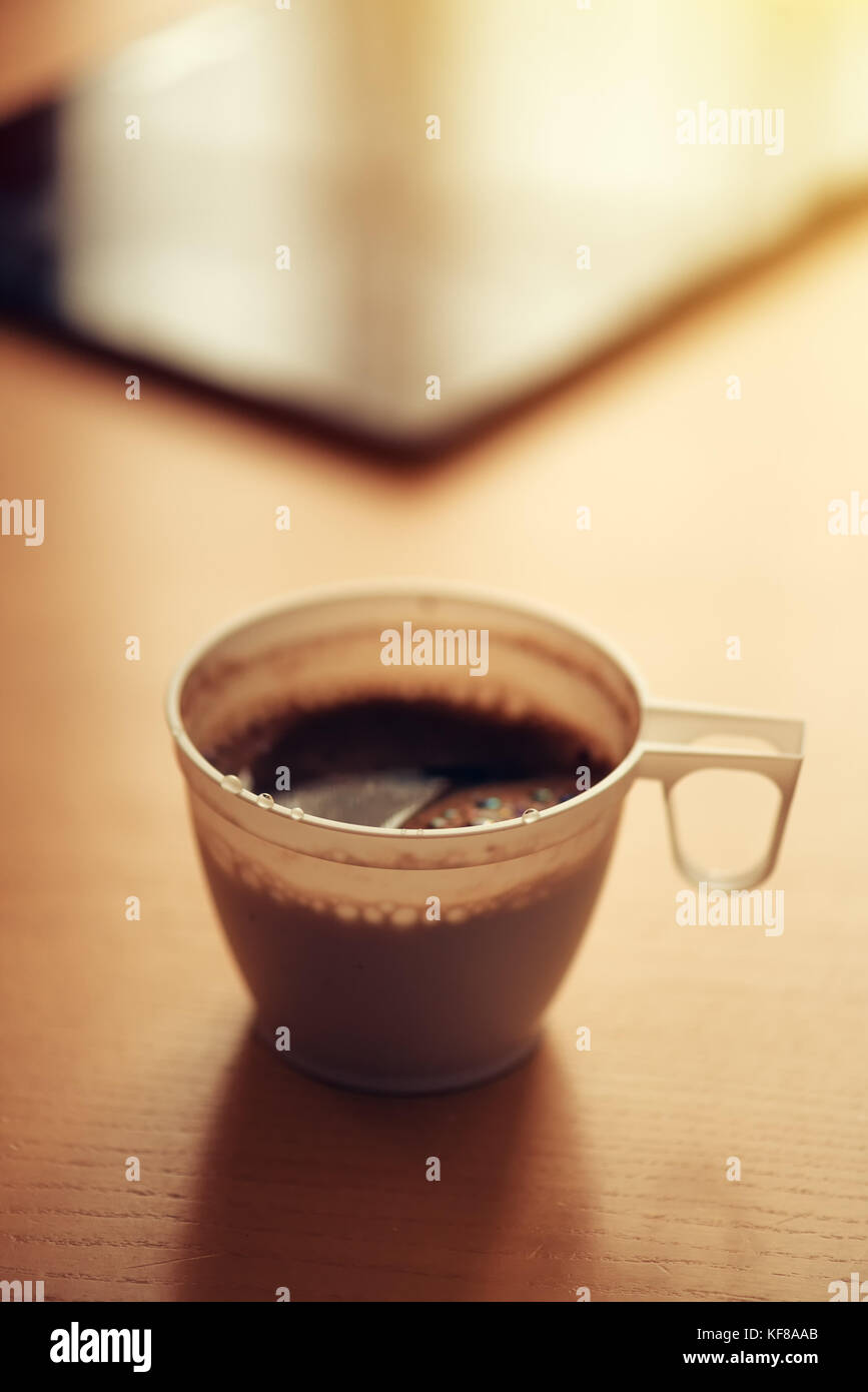 Le café du matin dans la tasse en plastique et tablet computer in background, selective focus Banque D'Images