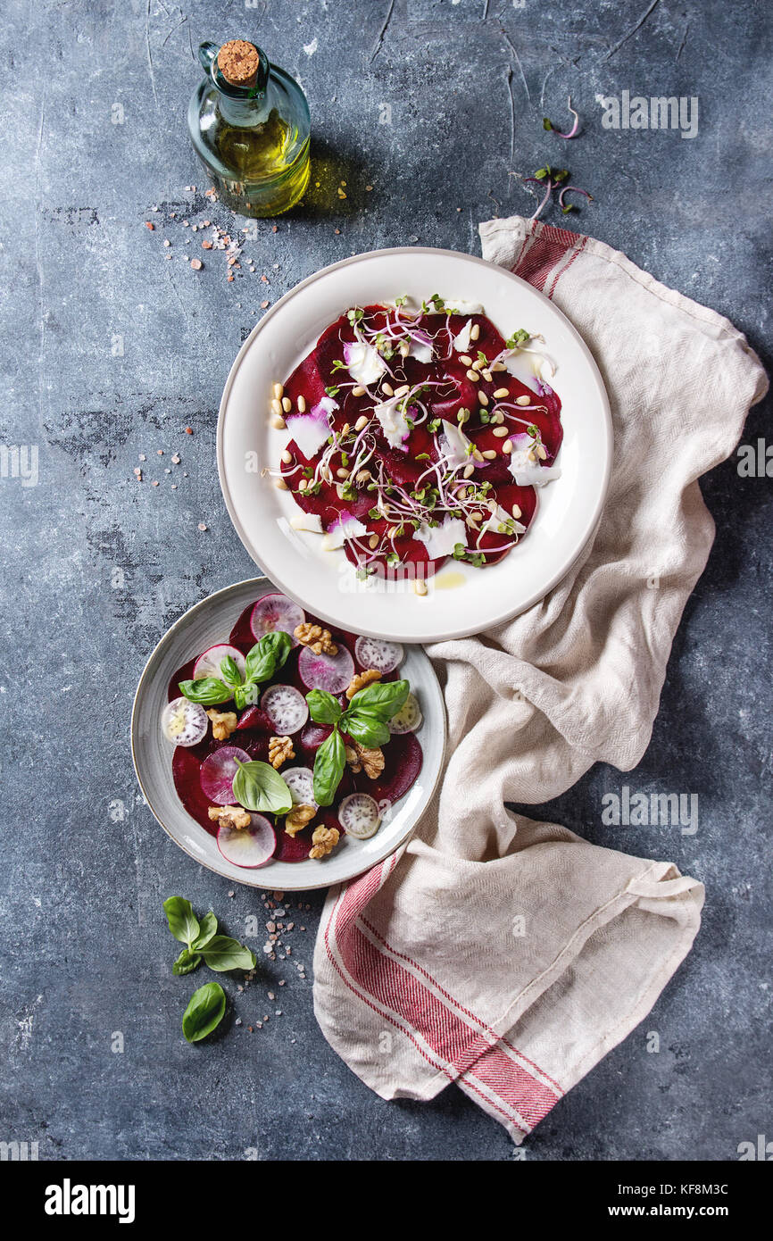 Carpaccio de betterave végétarien salade avec des radis, basilic, huile d'olive, fromage de chèvre, noix de pin, et les germes en deux sur la plaque plus serviette textile te bleu Banque D'Images