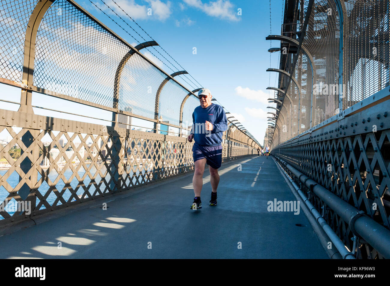 Un homme âgé jogger fait son chemin à travers le pont Harbour Bridge de Sydney à pied à Sydney en Australie. Banque D'Images