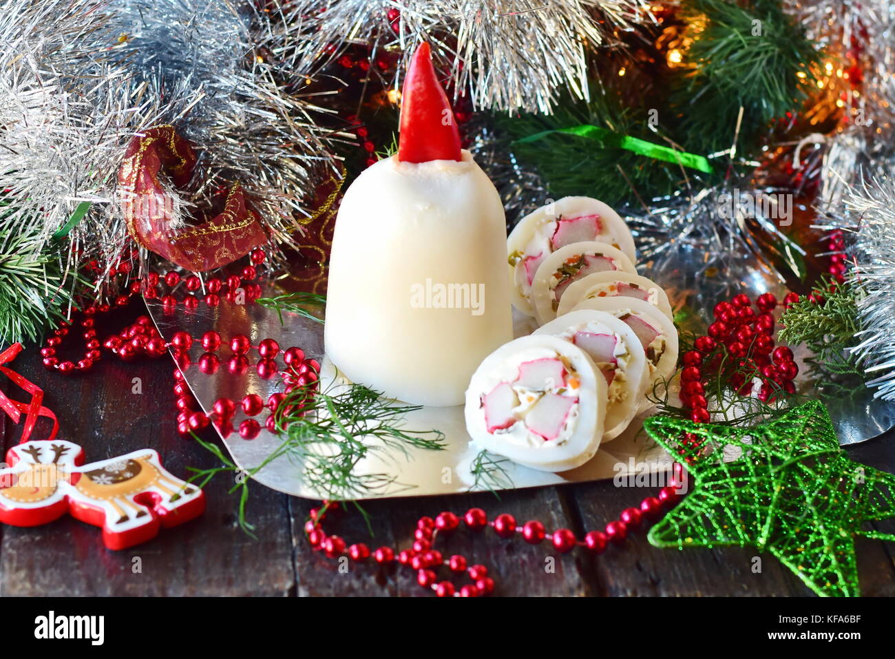 Encornets farcis avec de la mayonnaise, la gelée et les bâtonnets de crabe, façonné en forme d'une bougie de Noël Banque D'Images