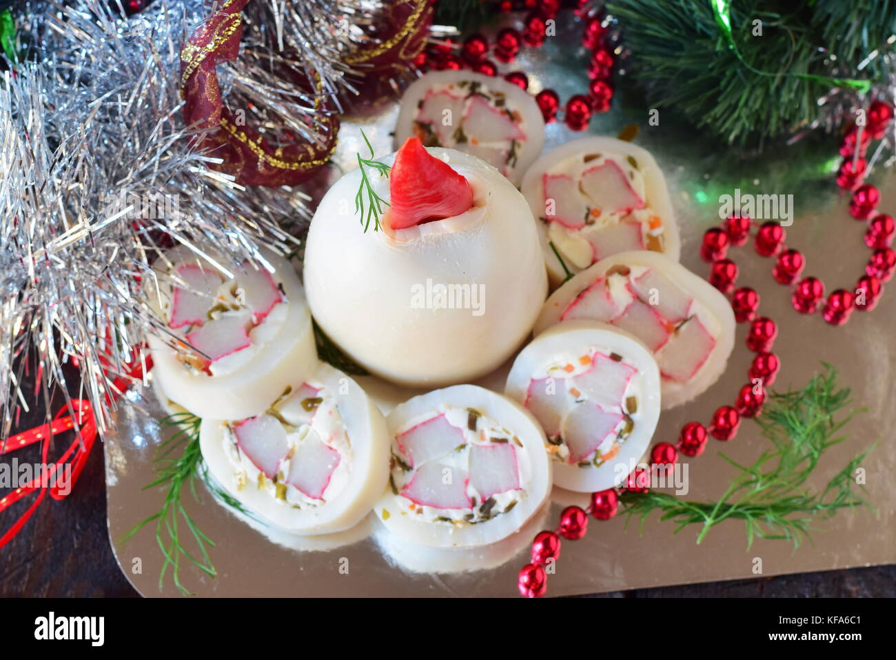 Encornets farcis avec de la mayonnaise, la gelée et les bâtonnets de crabe, façonné en forme d'une bougie de Noël Banque D'Images