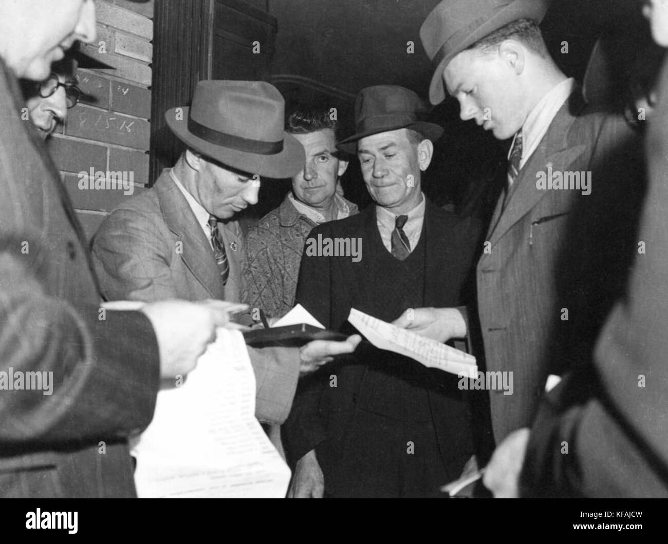 Image montrant des fonctionnaires vérifiant les documents de voyage dans une gare ferroviaire inter-états, mettant en évidence la sécurité des transports et les procédures de contrôle aux frontières. Banque D'Images