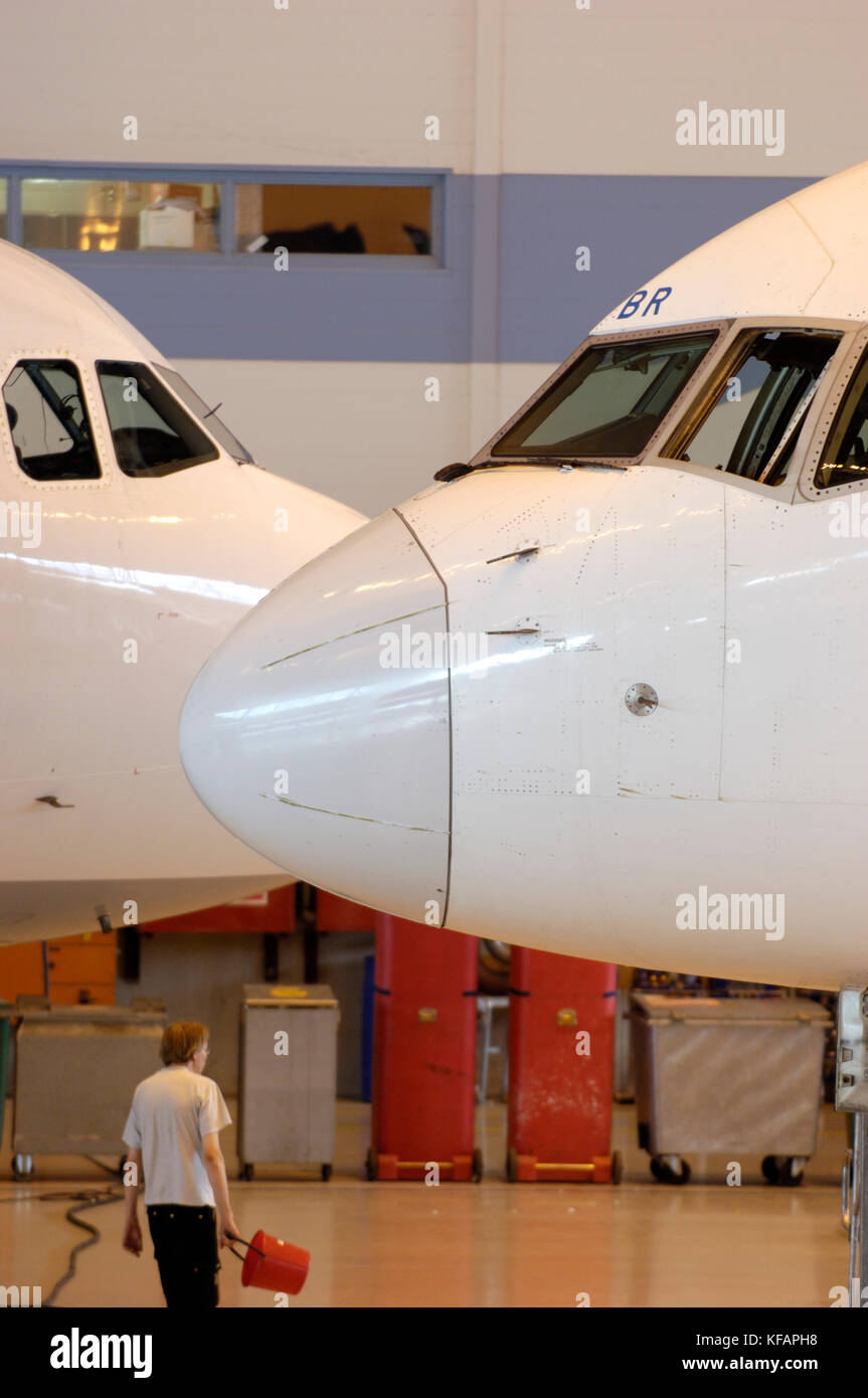 Homme marchant sous les pare-brise d'un Boeing 757-200 et Airbus A321-200 dans hangar Leko 7 chez Finnair Technical Services Banque D'Images