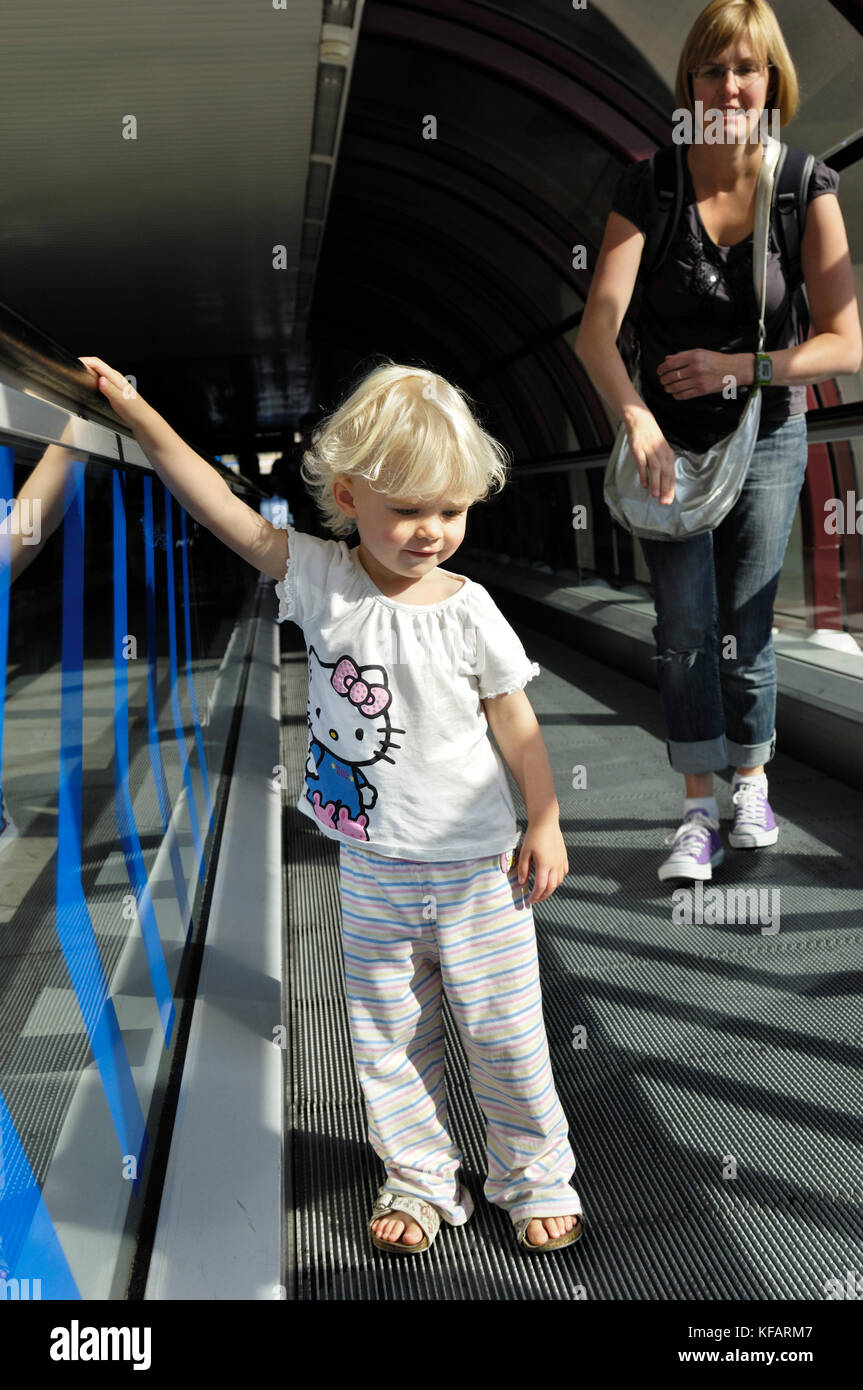 Polly et Steph debout sur déménagement-piétons tapis roulant dans le terminal Banque D'Images