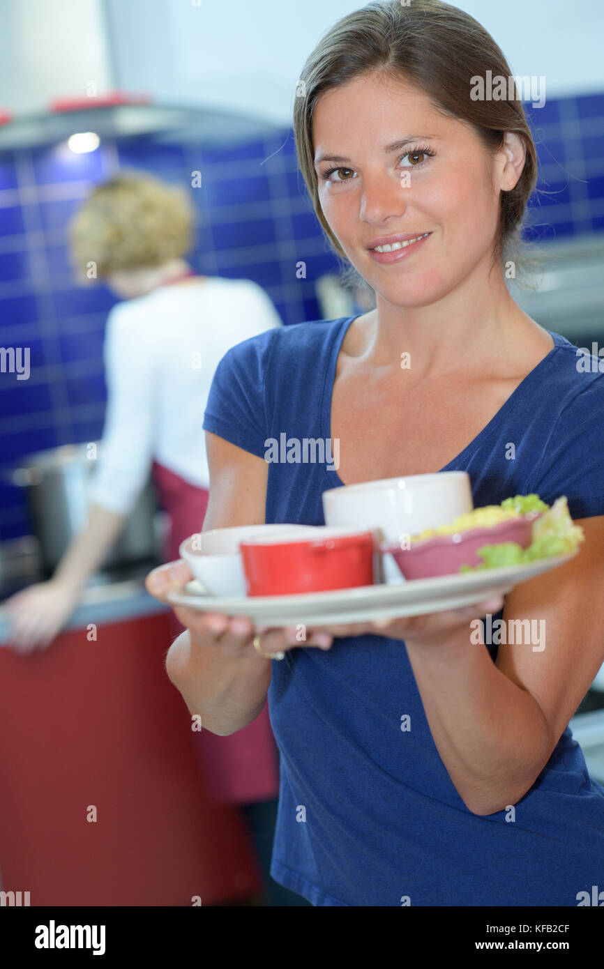 Jolie barmaid holding de salades dans les plaques d'un bar Banque D'Images