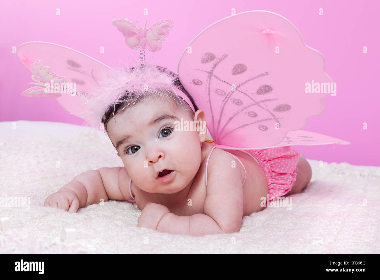 Mignon, joli, heureux, chubby et petite fille, avec des ailes de papillon roses et un serre-tête avec des papillons comme antennes. Quatre mois / bébé fille heureux mignon Banque D'Images