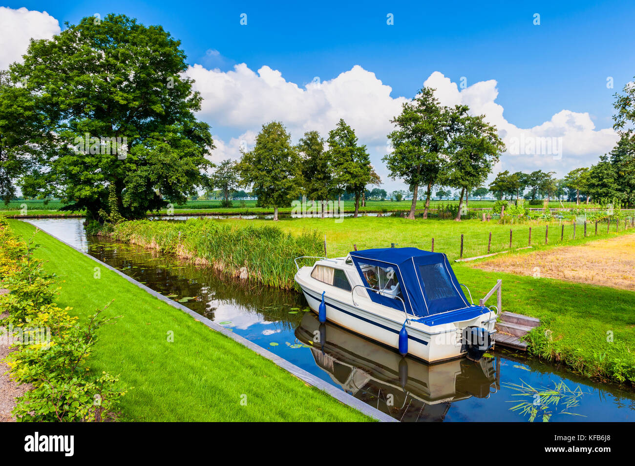 Petit canal avec bateau à moteur dans la région de giethoorn Pays-Bas le jour d'été Banque D'Images Petit canal avec bateau à moteur dans la région de giethoorn Pays-Bas le jour d'été Banque D'Images