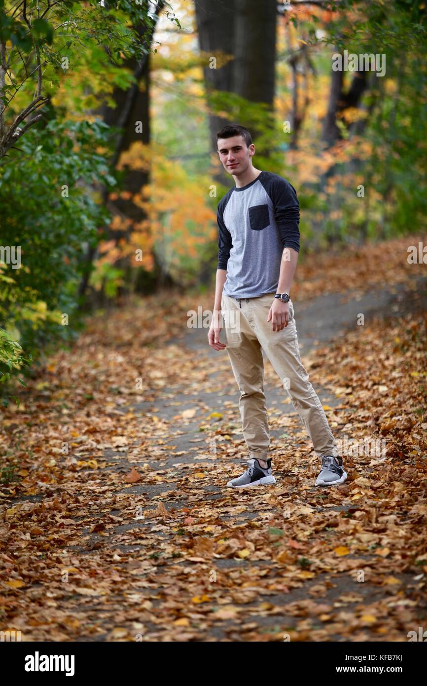 Teenage boy posant pour un portrait à l'extérieur tandis que l'occasion d'une randonnée dans une forêt en automne Banque D'Images