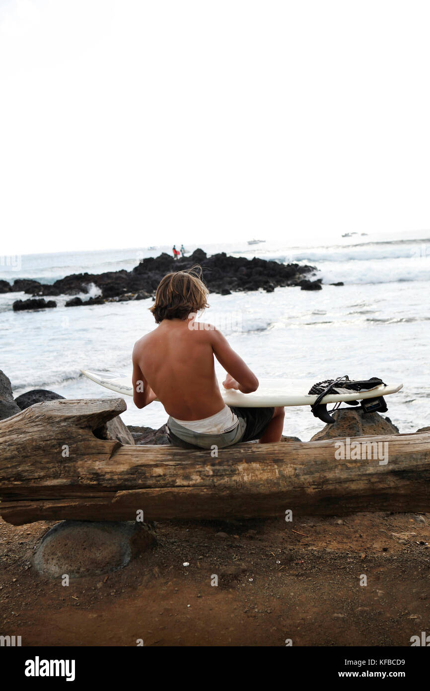 L'île de Pâques, CHILI, Isla de Pascua, Rapa Nui, cires d'un surfer son conseil avant d'entrer dans l'eau près de Hanga Roa Banque D'Images