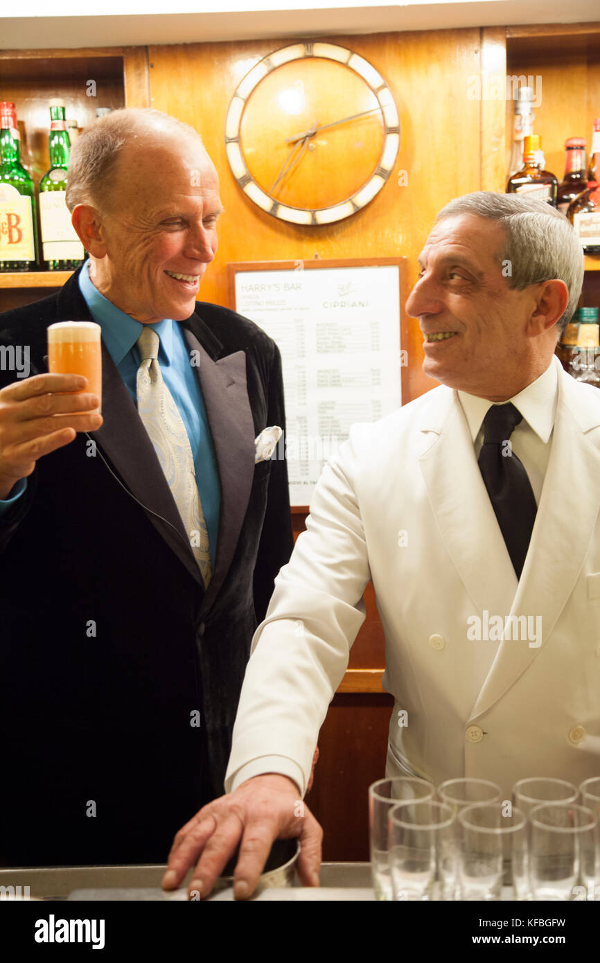 L'Italie, Venise. L'acteur Peter Weller le grillage avec un Bellini au Harry's Bar pour une célébration du Nouvel An. Banque D'Images