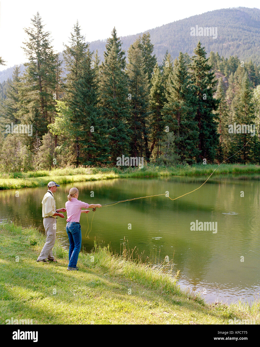 USA, Montana, femme la pêche à la mouche de la truite dans un lac, montagne Sky Guest Ranch Banque D'Images