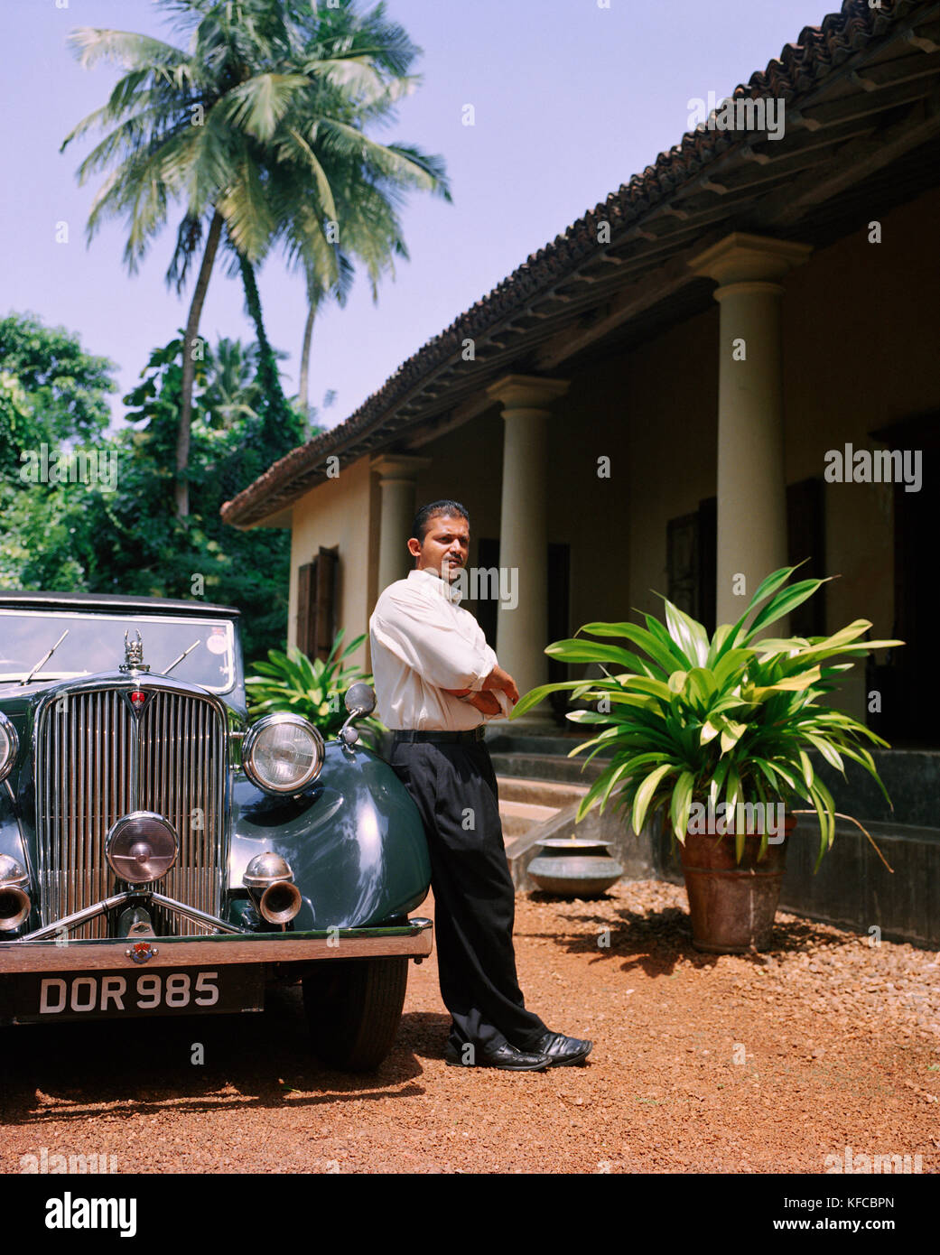 SRI LANKA, l'Asie, Galle, portrait d'un chauffeur standing by vintage car en face de la Dutch House Hotel. Banque D'Images