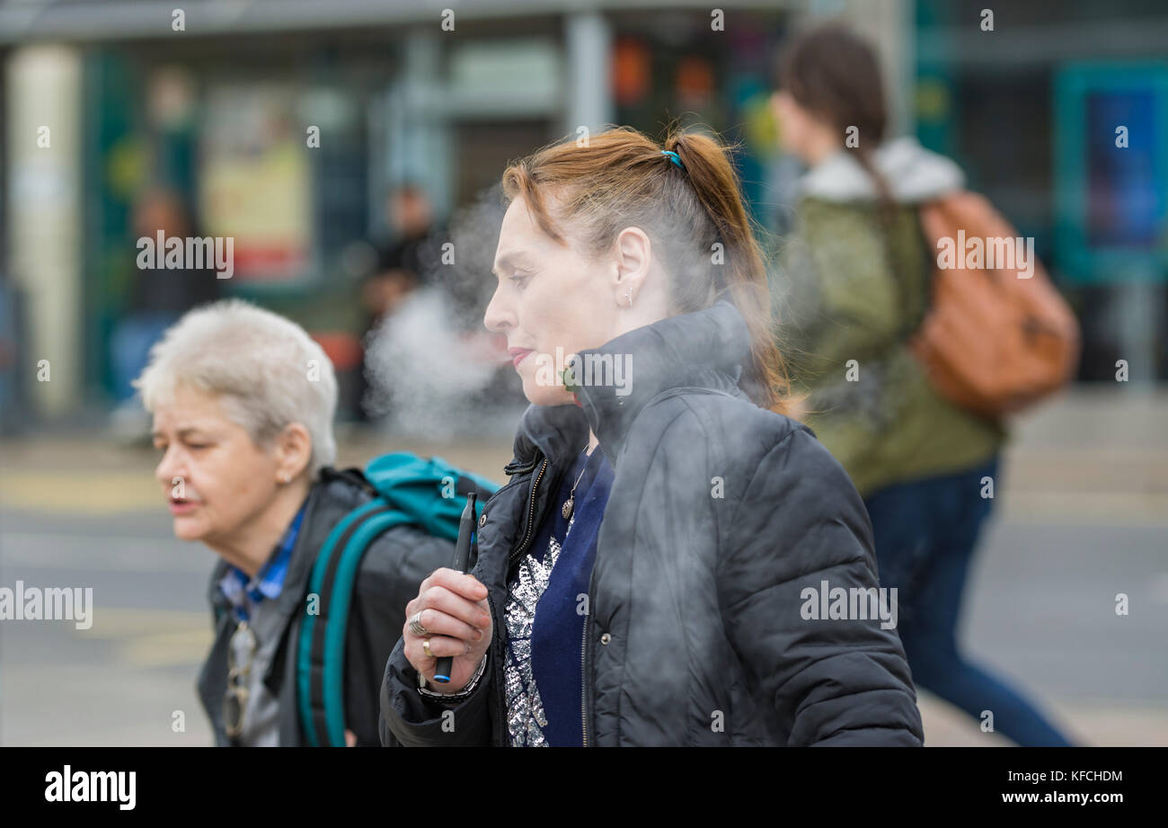 Femme caucasienne vapotage / fumer une cigarette électronique au Royaume-Uni. Banque D'Images Femme caucasienne vapotage / fumer une cigarette électronique au Royaume-Uni. Banque D'Images