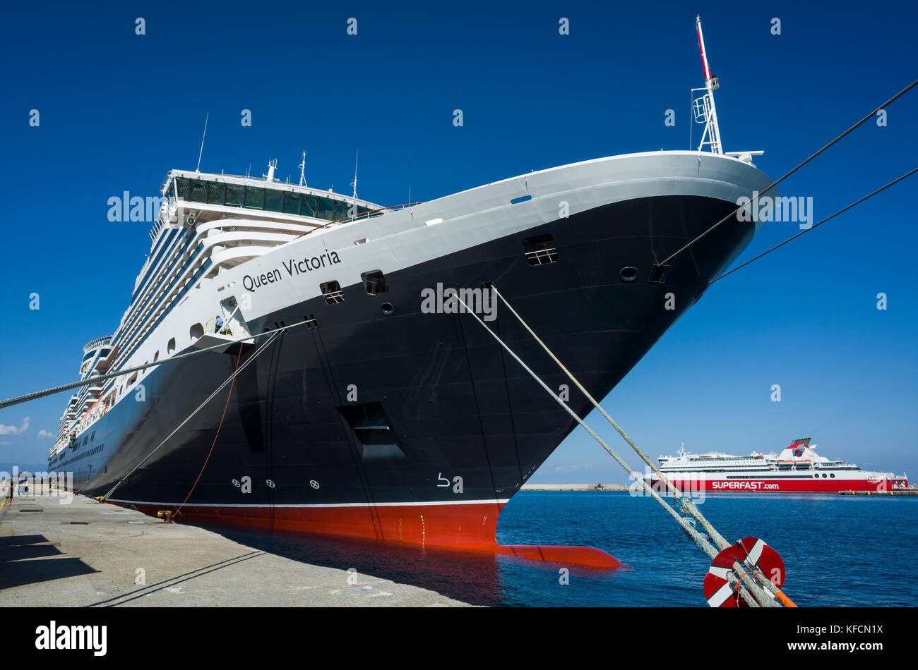 Port touristique de Rhodes, Rhodes. La Crète. La Grèce. Paquebot de croisière de luxe de Cunard, la reine Victoria, amarrés sur le quai. C'est une journée ensoleillée avec un pur ciel bleu se reflétant dans l'océan. Banque D'Images