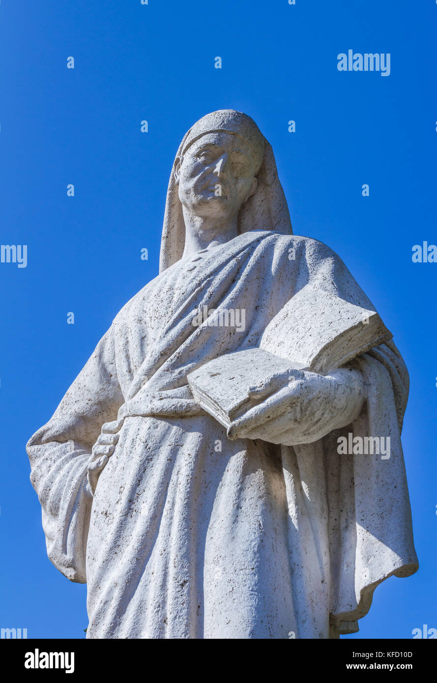 Statue du poète Dante Alighieri avec ciel bleu en arrière-plan. Le rédacteur a un livre à la main. Banque D'Images