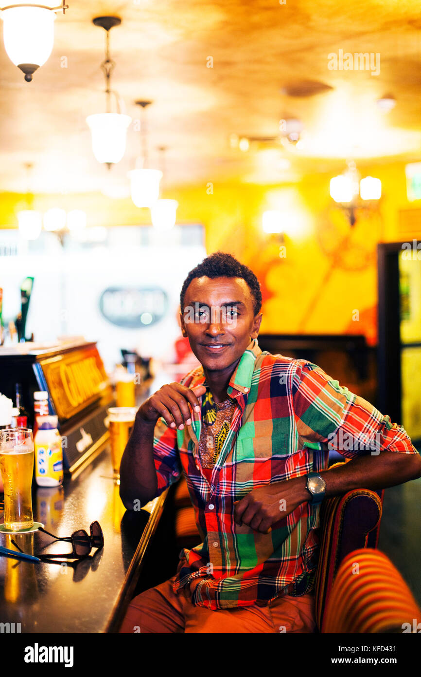 Les Bermudes, Hamilton. Soccerand chef Marcus Samuelsson regardant boire une bière au Flanagan's Bar au centre-ville de Hamilton. Banque D'Images