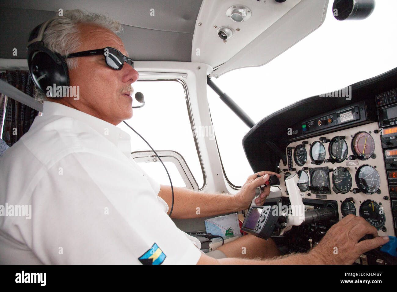 EXUMA, Bahamas. Le pilote aux commandes, l'hélice avion vers les îles Exuma. Banque D'Images