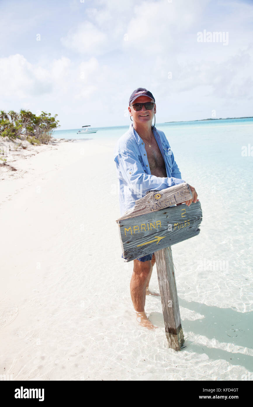 EXUMA, Bahamas. Yves, tenant une pancarte sur Boussole Cay. Banque D'Images