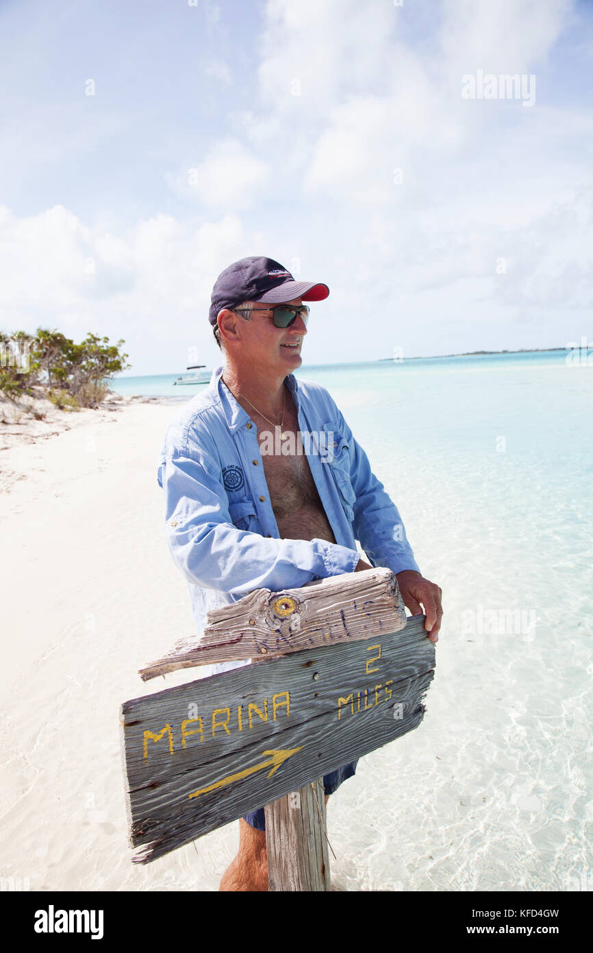 EXUMA, Bahamas. Yves, tenant une pancarte sur Boussole Cay. Banque D'Images