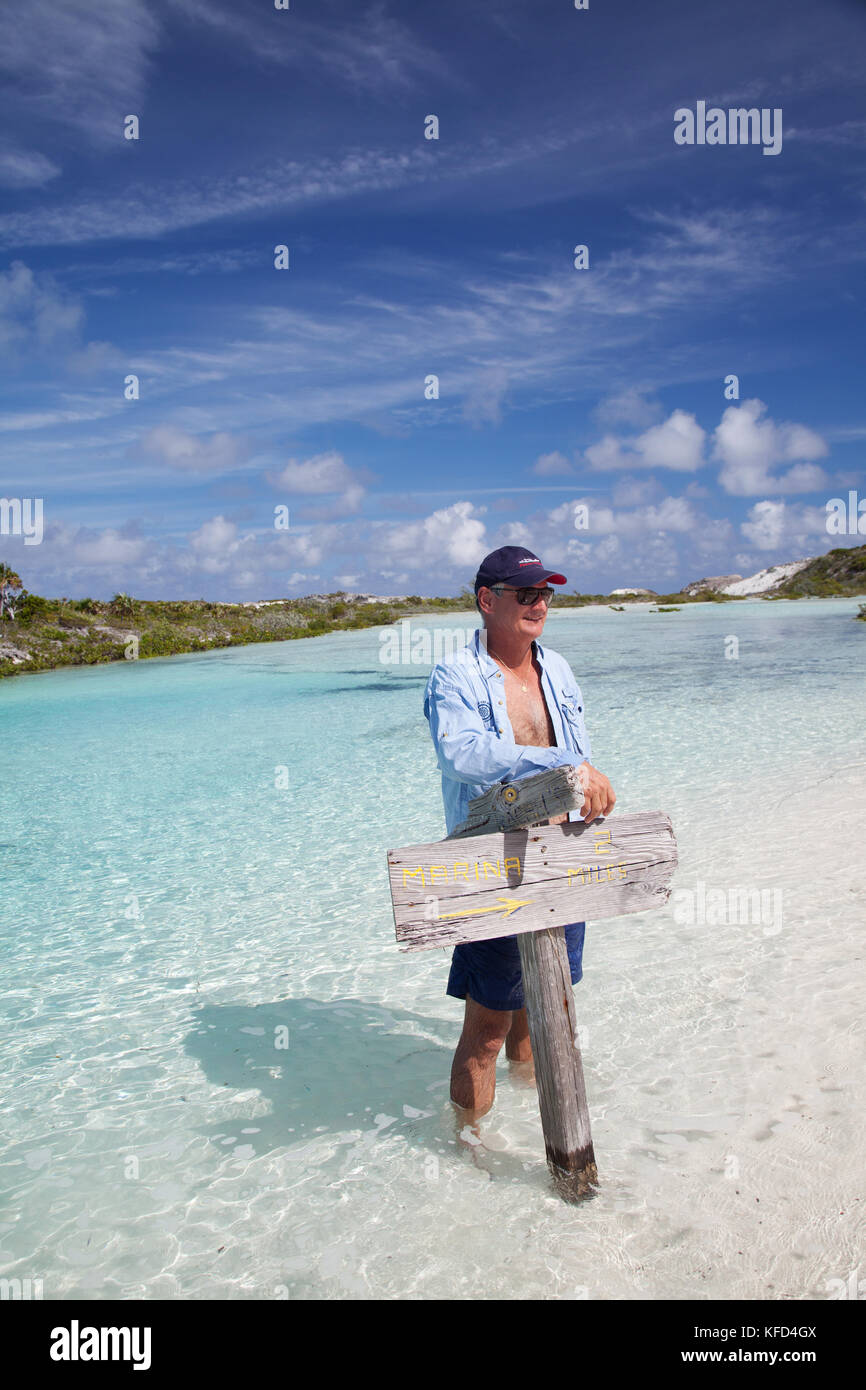 EXUMA, Bahamas. Yves, tenant une pancarte sur Boussole Cay. Banque D'Images