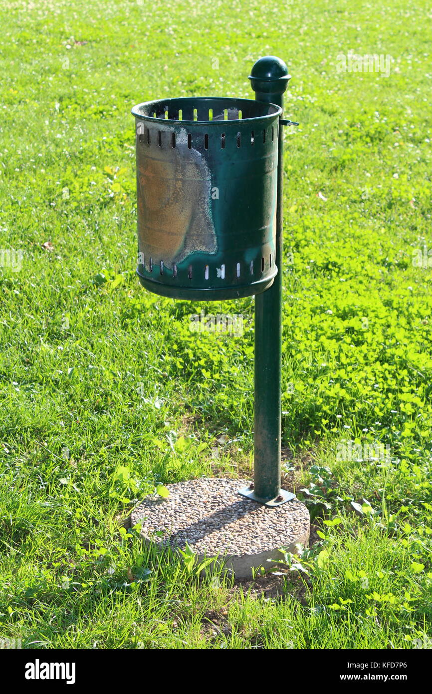 Vieux vert utilisé et battus vers le bas avec une poubelle publique vis à  béton sur l'herbe verte non coupée Photo Stock - Alamy