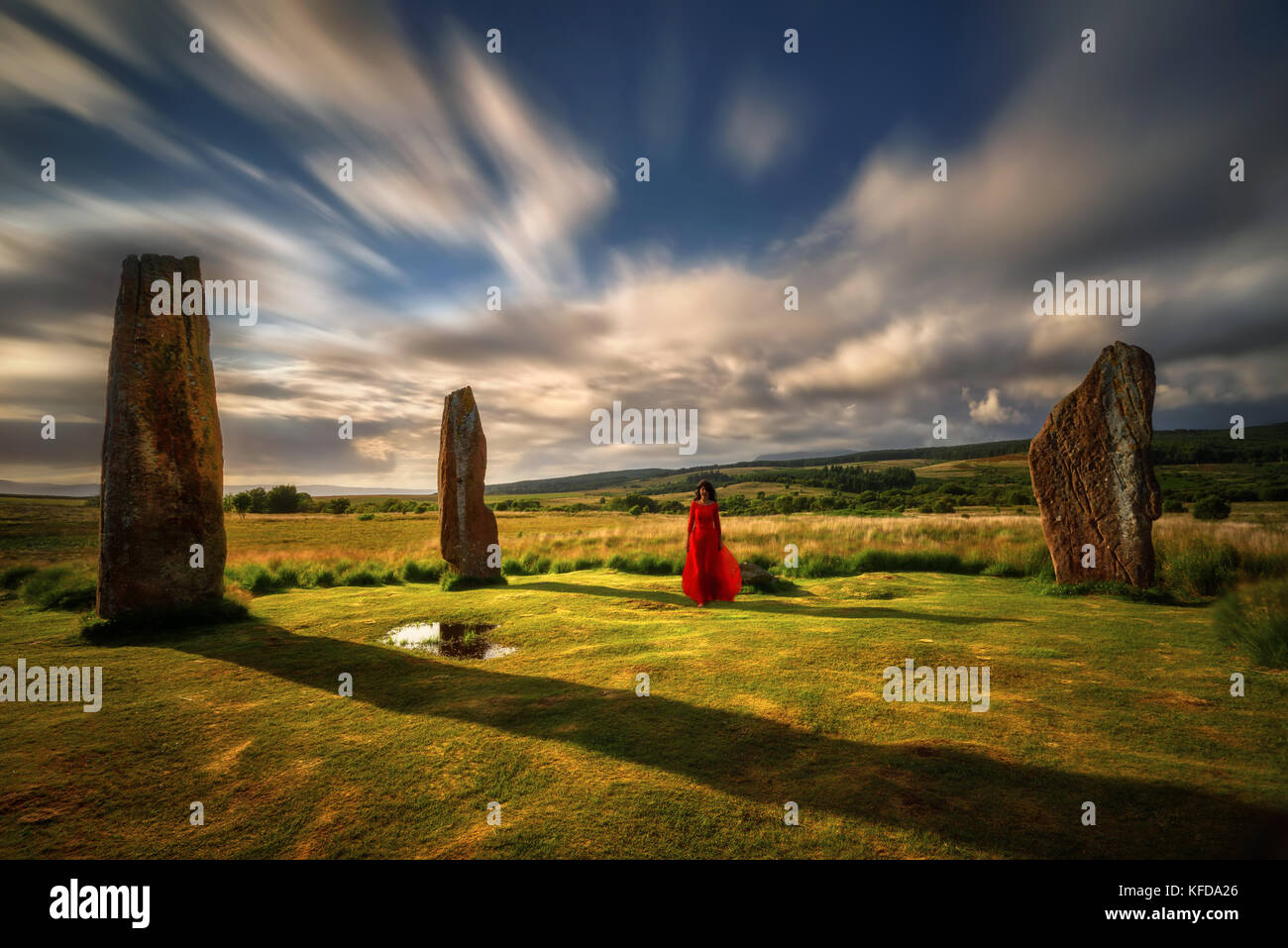Femme en robe rouge en machrie moor pierres, Isle of arran, Ecosse Banque D'Images