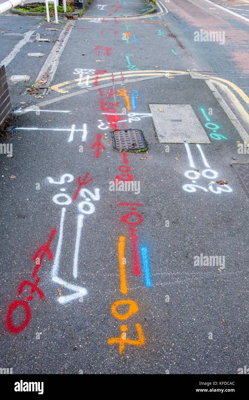 Diverses marques sur la chaussée indiquant les tuyaux enterrés et les câbles pour les services publics, Lancashire, England, UK Banque D'Images