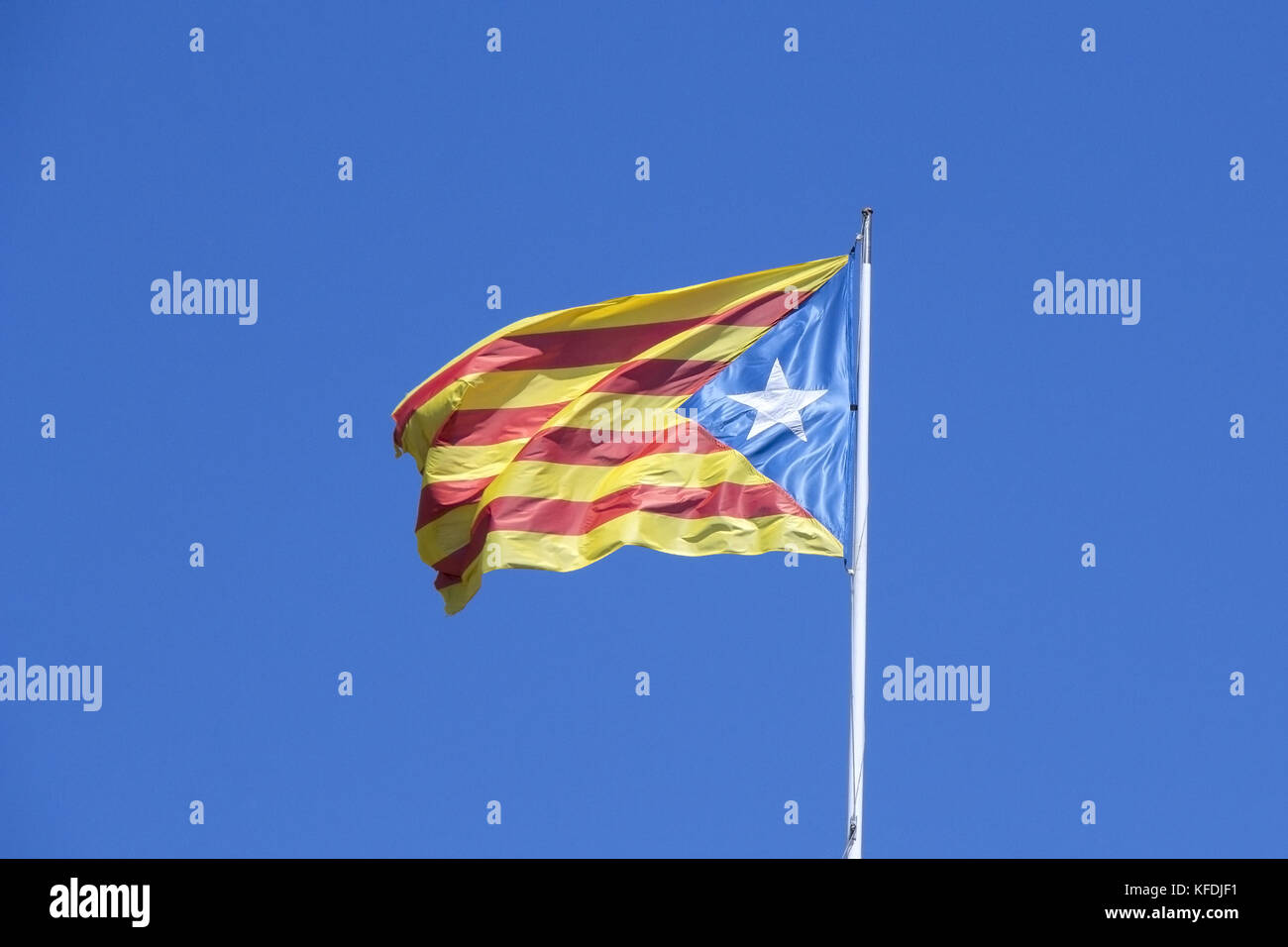 Drapeau catalan sur le vent dans le ciel bleu Banque D'Images