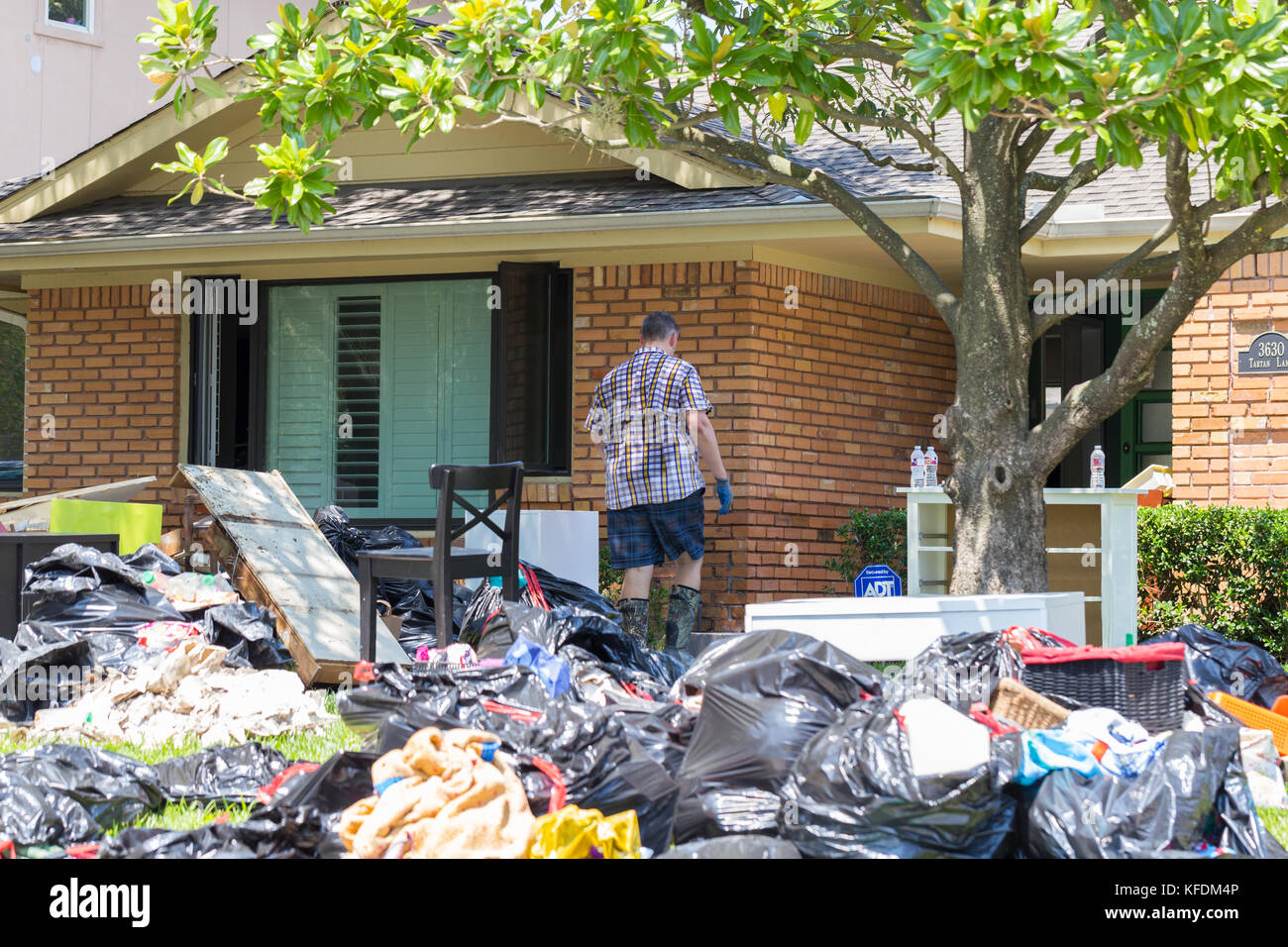 Le nettoyage commence à Houston après l'ouragan Harvey et de fortes inondations. une famille se déplace à partir de leurs effets personnels accueil inondées Banque D'Images