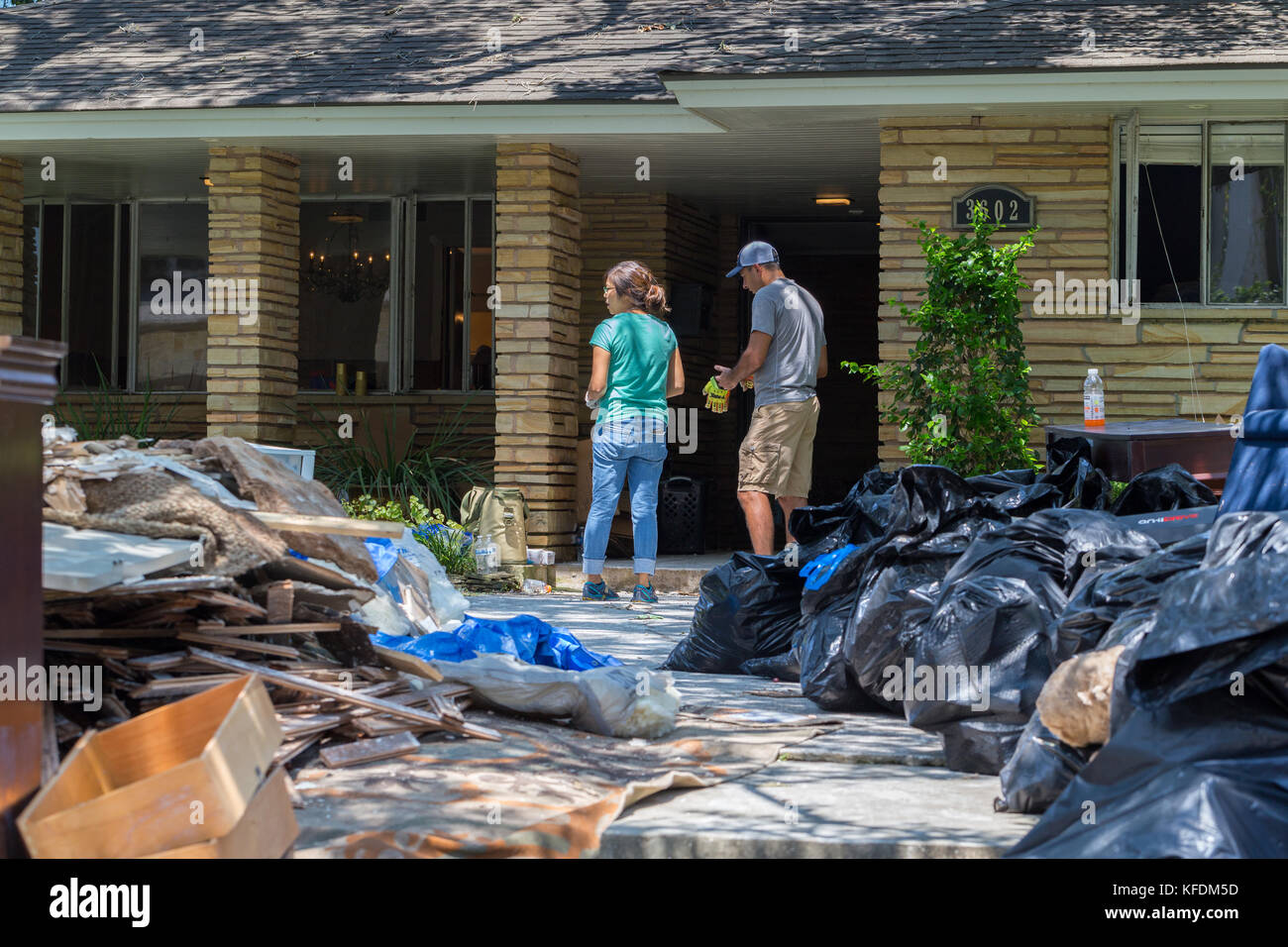 Le nettoyage commence à Houston après l'ouragan Harvey et de fortes inondations. une famille se déplace à partir de leurs effets personnels accueil inondées Banque D'Images