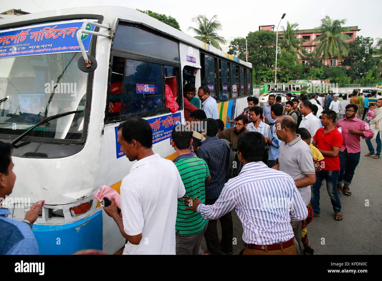 Les gens du Bangladesh tente de monter dans un bus bondé de voyage d'accueil, comme d'autres attendent pour le transport avant l'iftar, à Dhaka, Bangladesh Banque D'Images