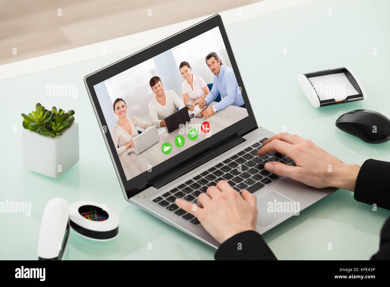 Close-up of man videochatting avec des collègues à l'ordinateur Banque D'Images