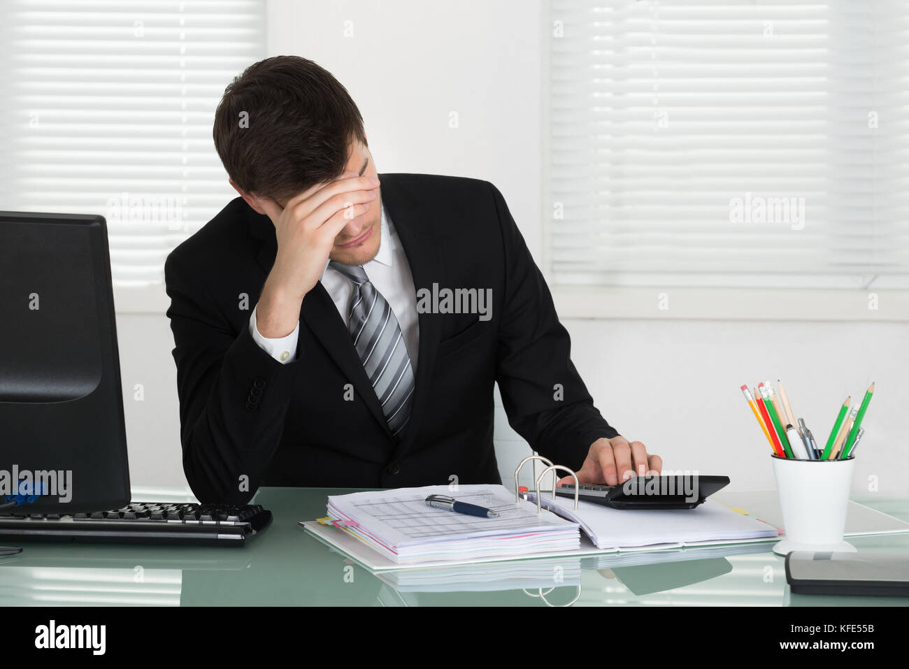 Souligné young businessman calcul loi in office Banque D'Images