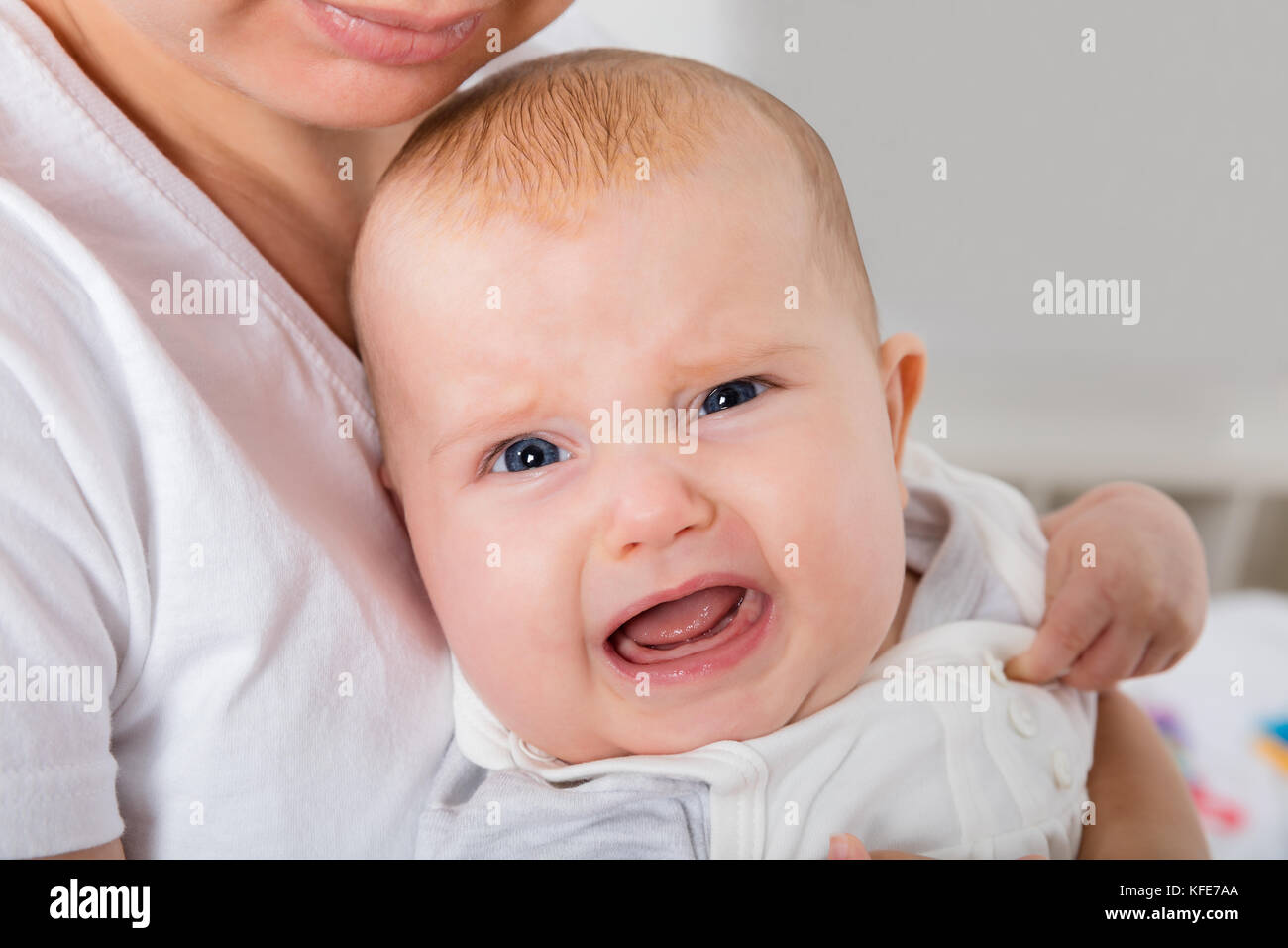Gros plan d'Un enfant qui pleure sur le bras de la mère Banque D'Images