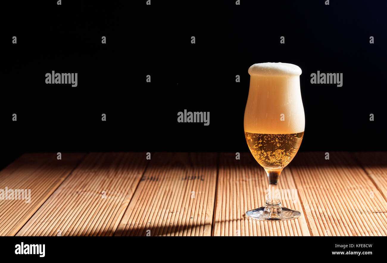 Un verre de bière sur une table en bois, fond sombre, copy space Banque D'Images