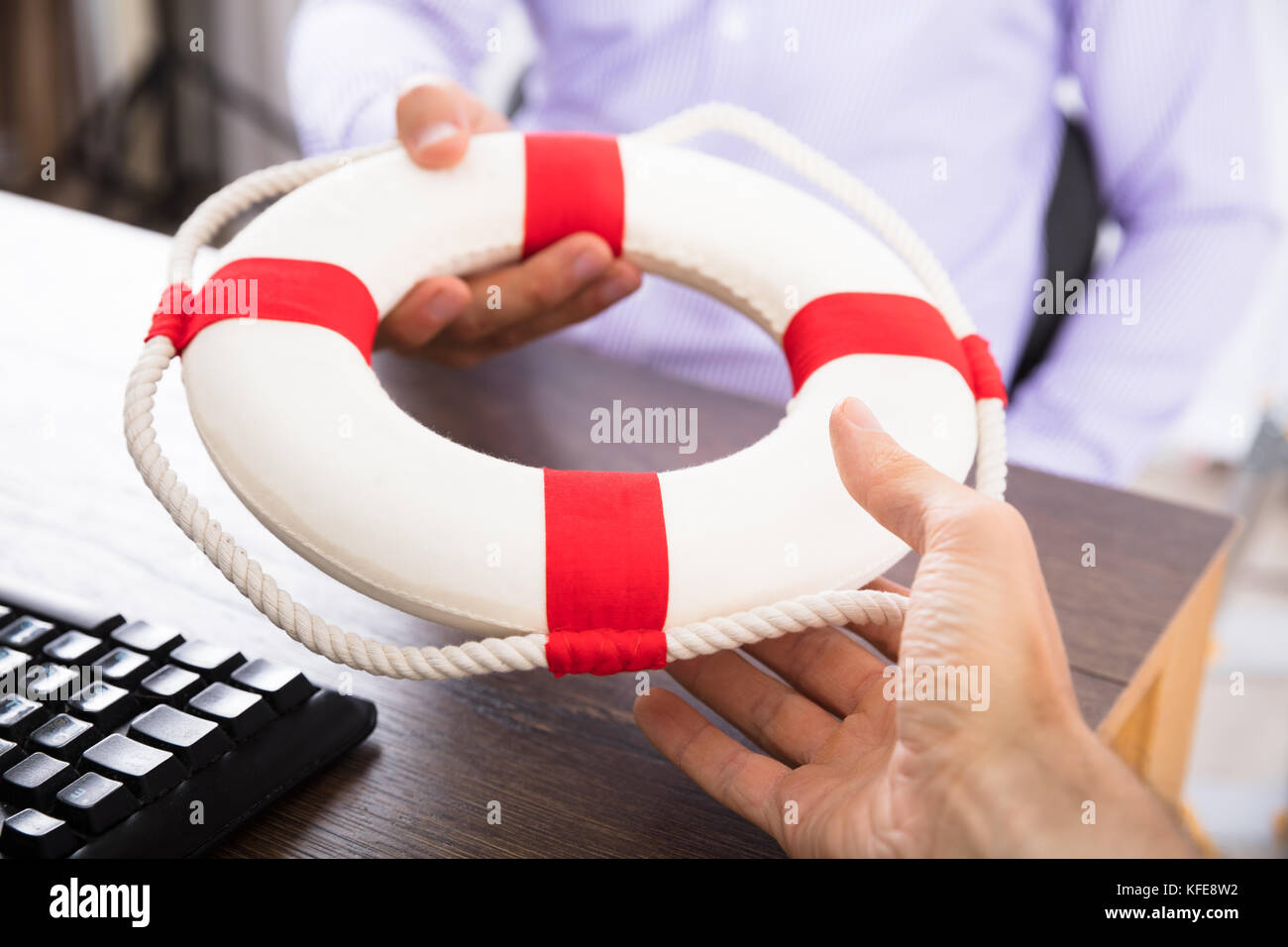 Close-up of a Businessman's Hand passant une bouée à son partenaire dans le bureau Banque D'Images