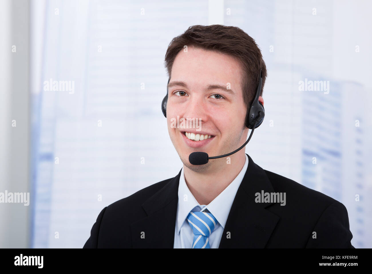 Portrait of young businessman wearing headset in office Banque D'Images