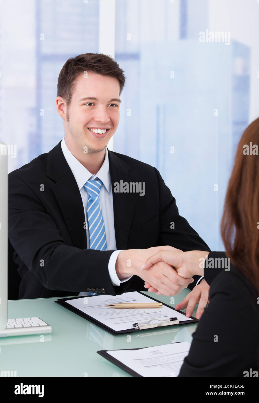 Young businessman shaking hand de candidate during job interview Banque D'Images