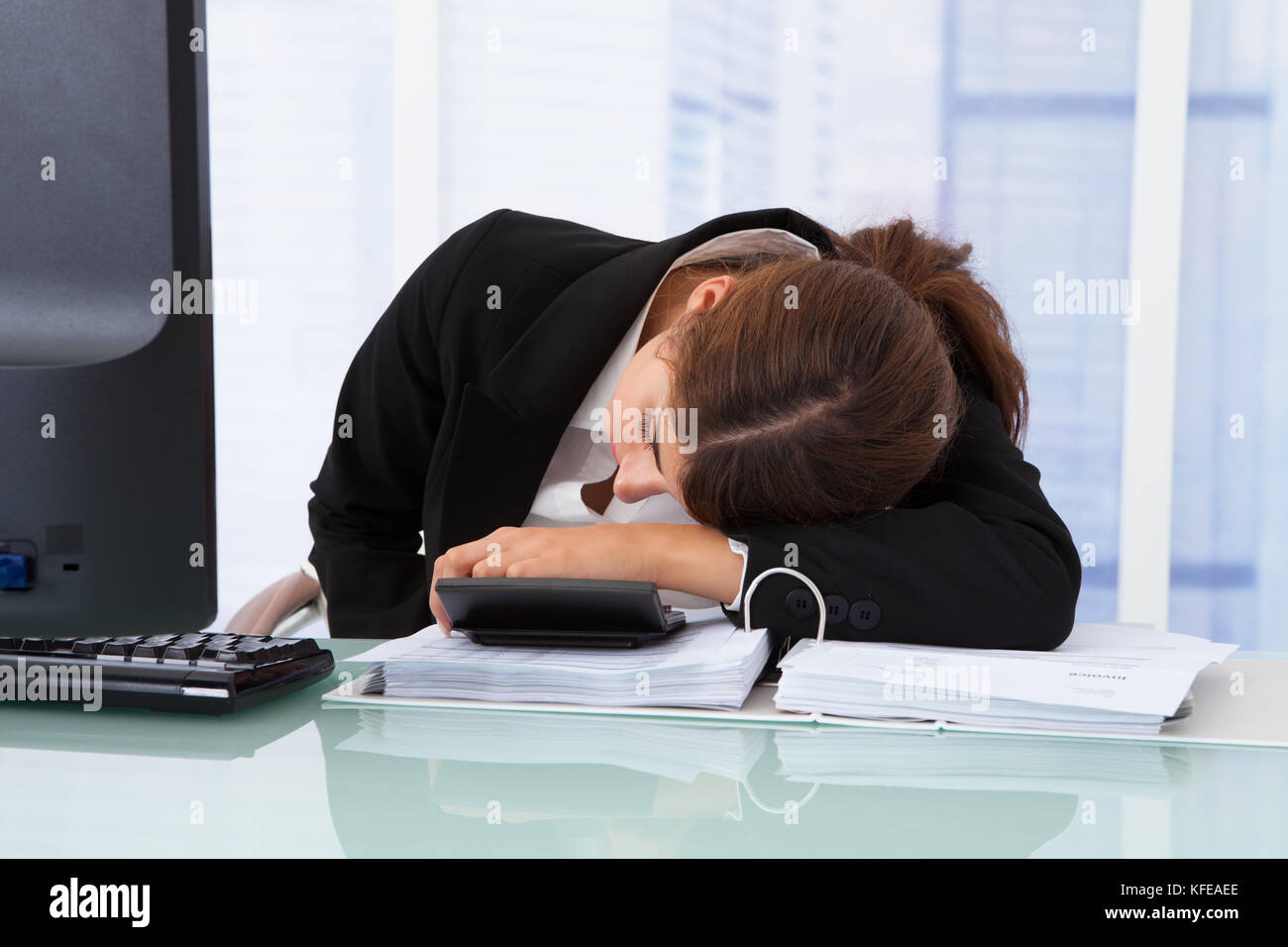 L'accent sur les jeunes woman smiling at desk in office Banque D'Images