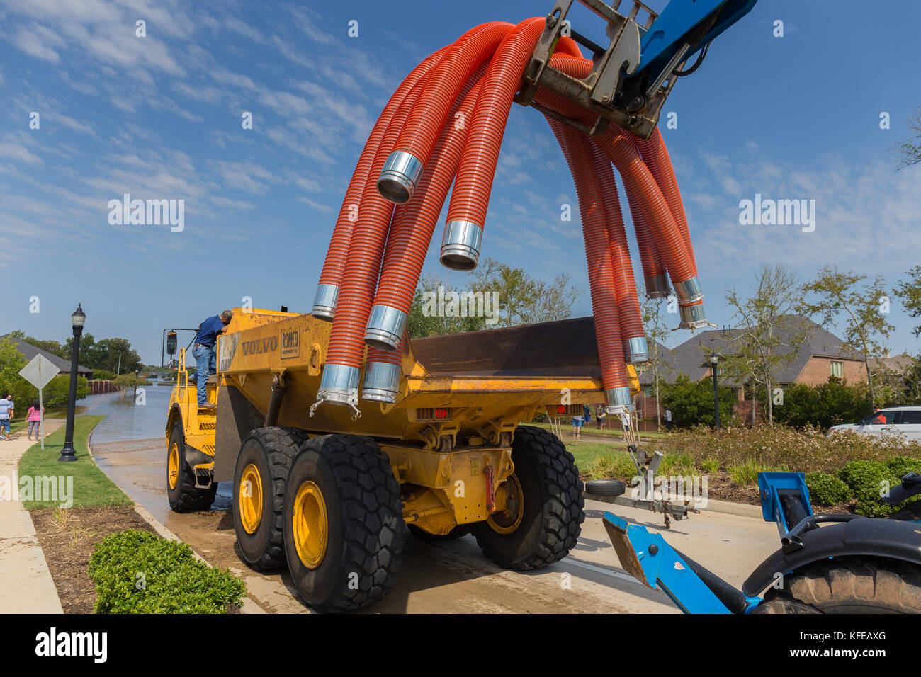 L'équipement d'affaires - un chariot élévateur charge flexible tubes utilisés pour le pompage des eaux d'inondation dans un camion-benne Banque D'Images