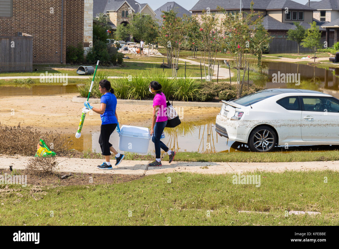 Démarrer les résidents de leur eau de nettoyage des maisons endommagées après l'ouragan Harvey et de fortes inondations. Banque D'Images