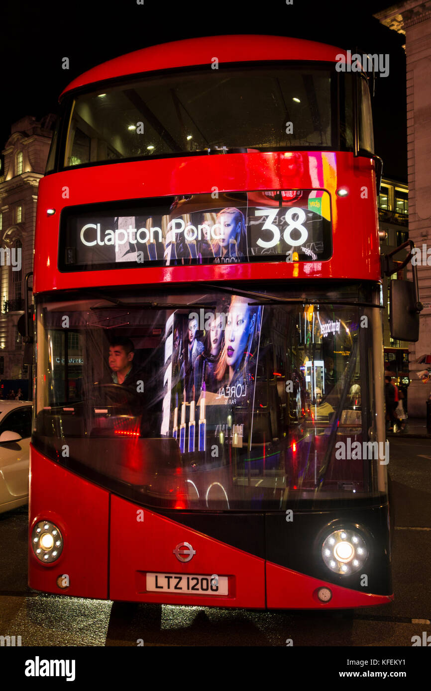 Un bus Routemaster reflétant les lumières de la courbe panneaux publicitaires sur Piccadilly Circus Banque D'Images