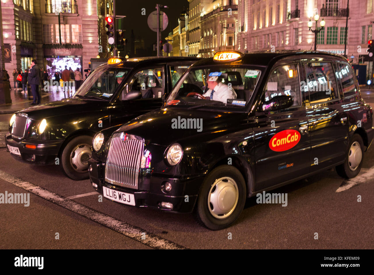 London taxis noirs attendent les lumières de changer sur Piccadilly Circus, Londres, UK Banque D'Images