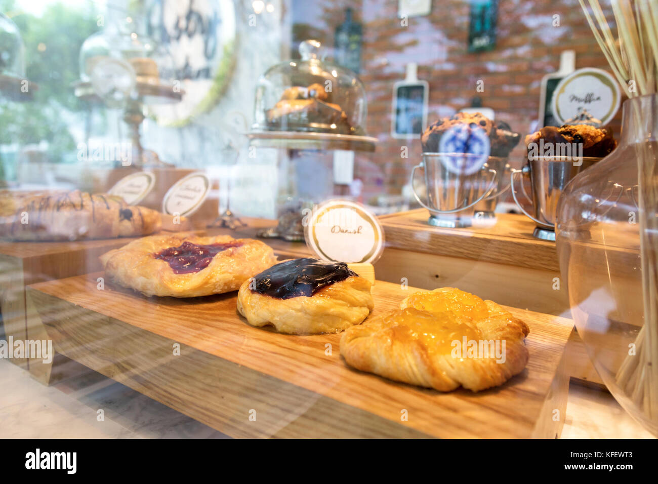 Myrtille, fraise et pêche dans les pâtisseries danoises s'affichent avec la réflexion de la lumière sur la vitre au bakery shop. focus sélectif. Banque D'Images