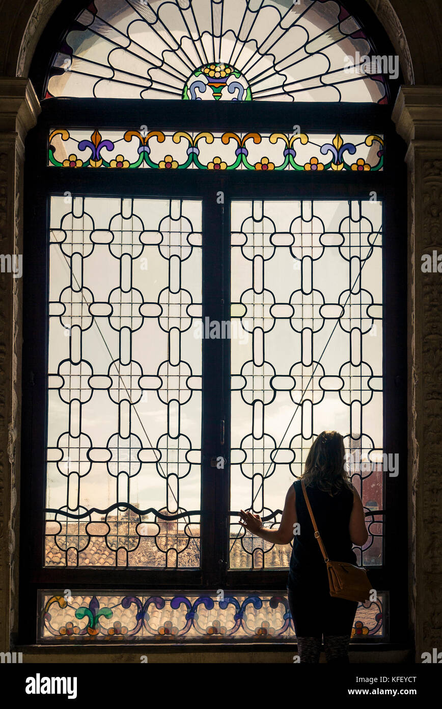 La femme regarde la grande fenêtre du Palais des Doges vers le pont de Sigh's à Venise, en Italie Banque D'Images