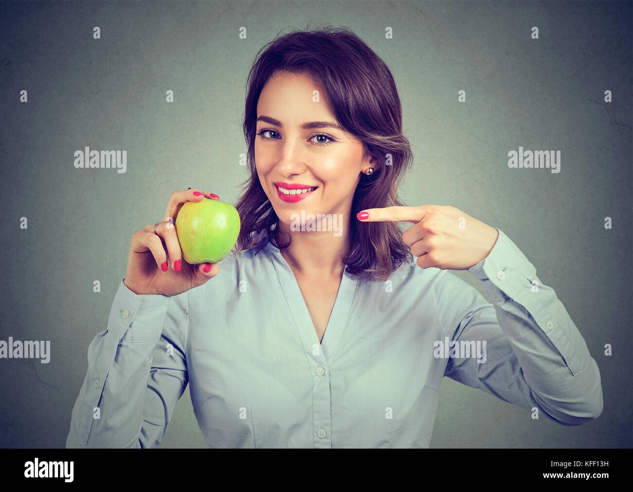Happy woman pointing at green apple Banque D'Images